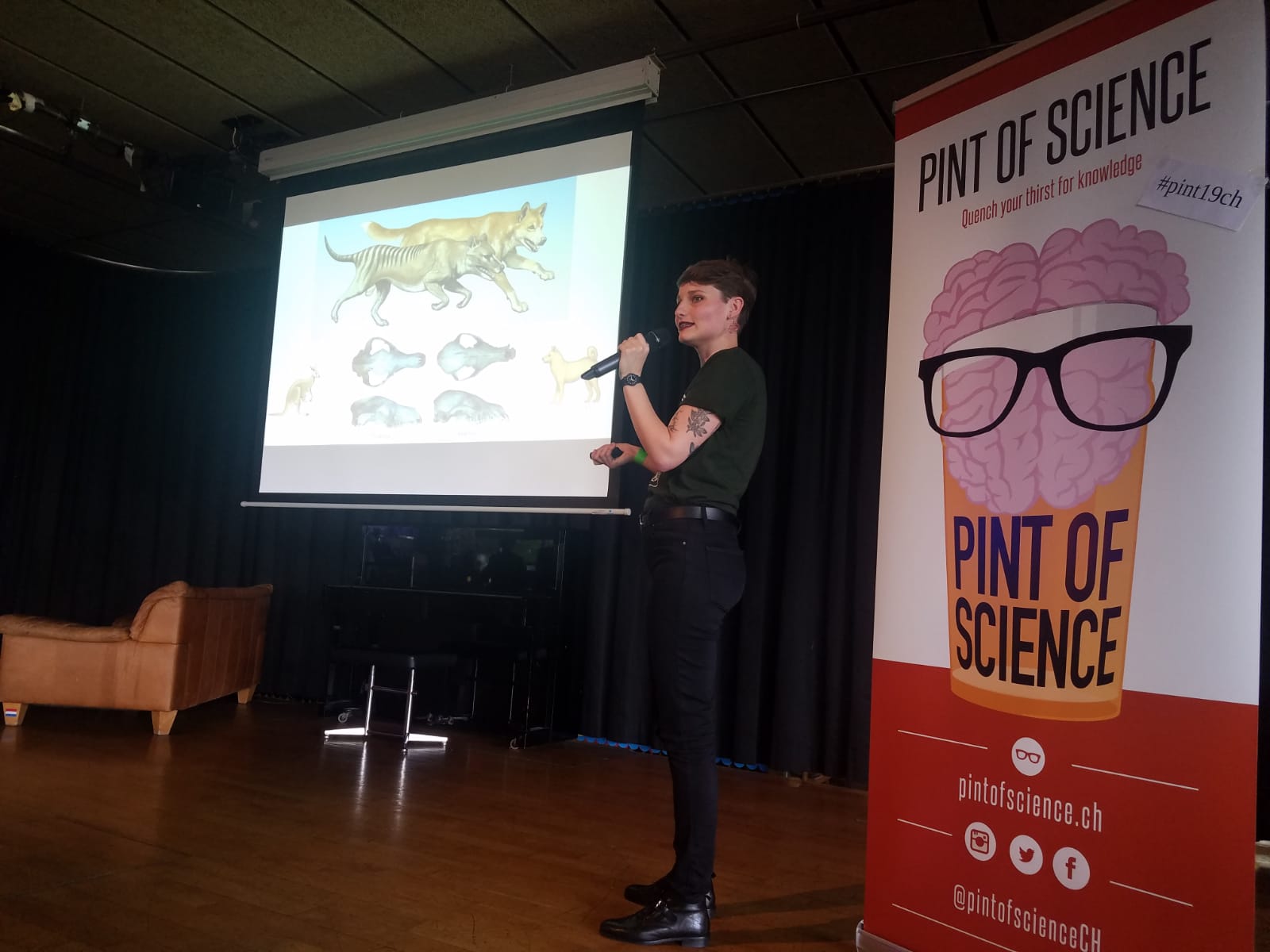 person holding a microphone and presenting scientific content at a public event