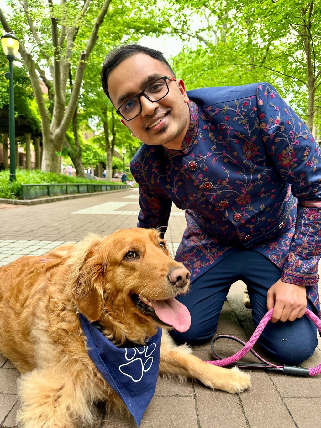 a man with a golden retriever smiling at the camera